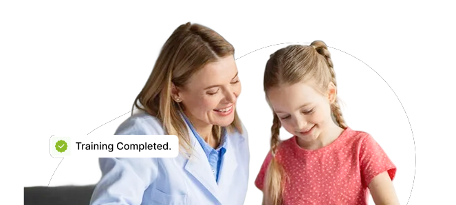 Woman in a light blue lab coat smiles with a young girl as a small 'Training Completed' notification bubble appears nearby.