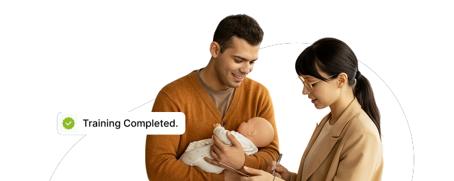 Man holding a newborn while a healthcare professional listens to the baby with a stethoscope; a 'Training Completed' badge is visible.
